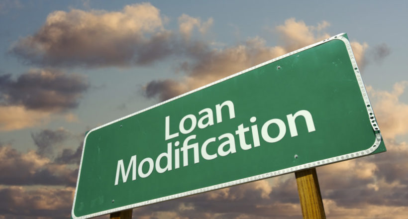 Loan Modification Green Road Sign with dramatic clouds and sky.