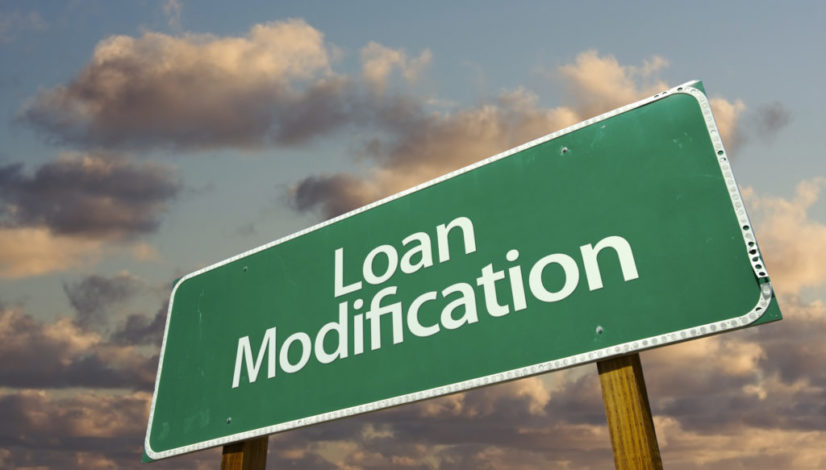 Loan Modification Green Road Sign with dramatic clouds and sky.