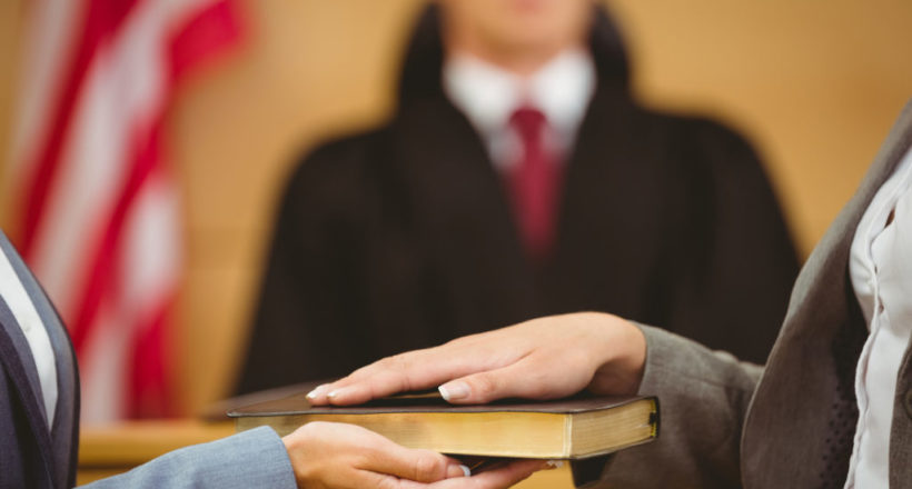 Witness swearing on the bible telling the truth in the court room