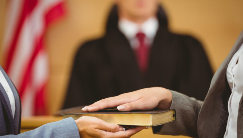 Witness swearing on the bible telling the truth in the court room